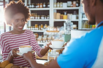Waiter serving a coffee to a woman