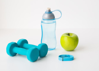 dumbbells, fitness tracker, apple and bottle