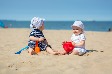 Baby twins playing at the beach of Baltic Sea, Poland