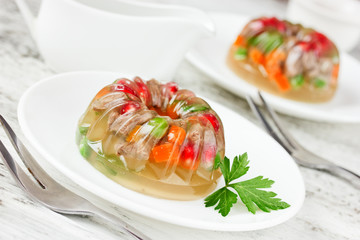 Aspic decorated with pomegranate, green peas, carrot and parsley