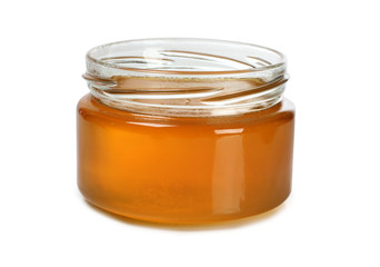 Glass jar with honey on white background