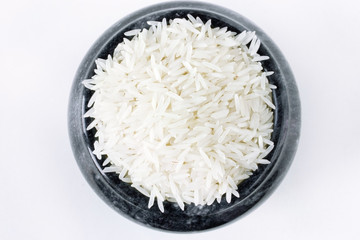 Polished long rice basmati in a stone bowl top view isolated