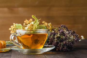 liquid honey with honeycomb and tea cup inside bunch of dry herb