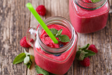 Top view on detox berry smoothie in glass jar with mint.