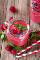 Top view on detox berry smoothie in glass jar with mint.