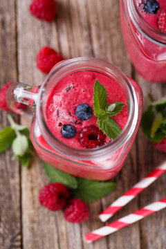 Top view on detox berry smoothie in glass jar with mint.