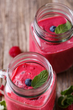Top view on healthy berry smoothie in glass jar.