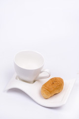 White cup for coffee with croissant over white background