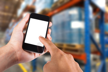 Person using smartphone white screen holder on hand with blurry background of industrial factory.