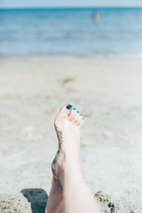 Vacation holidays. Woman feet closeup of girl relaxing on beach