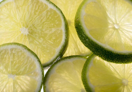 Background image of sliced green limes. Back lit.