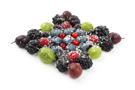 lot of different berries in the shape of a square on a white bac