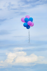 balloons on the cloudy day, pink and blue balloons with blurred sky background and copy space, hope and dream on the blue day concept