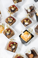 mini canapes in plastic cups decorated with edible flowers