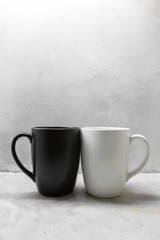 Black and white coffee mug on concrete table