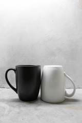 Black and white coffee mug on concrete table