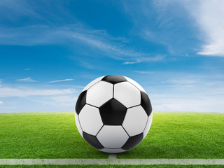 soccer ball on green field and blue sky background