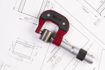 Metal cylinders and micrometer on printed engineering drawings. Mechanics and Engineering...