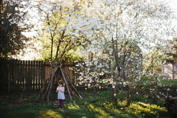 Girl standing in garden with a den 