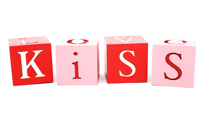 Valentine message. Isolated colored wood blocks, with the word kiss painted.