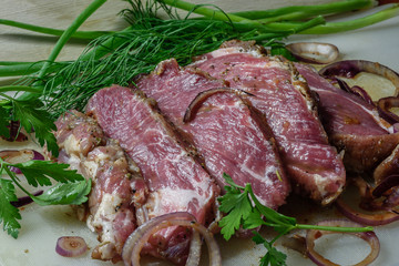 chunk of meat marinated in chili sauce with onion, herbs, sliced steak and ready for frying