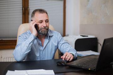 Businessman in his office talking on the phone emotionally