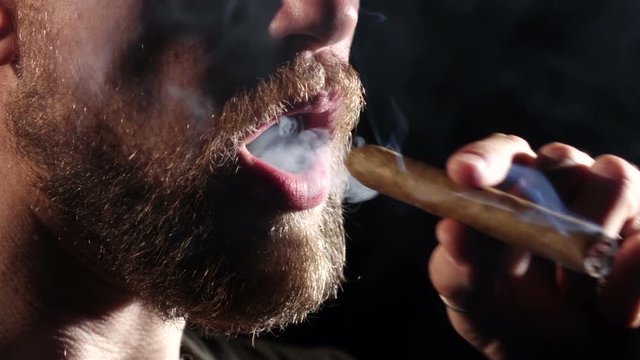 Detail of a person smoking cigar. Black. Close up. Slow motion
