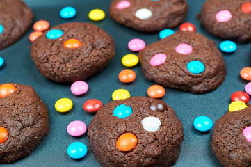 Chocolate cakes made by children. Cookies with colorful candies