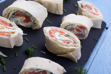 Roll from red fish with cheese and greens