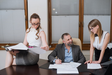 Businessman and his assistants secretaries in his office.