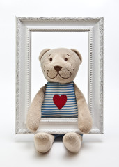 A Teddy bear with white photo frame