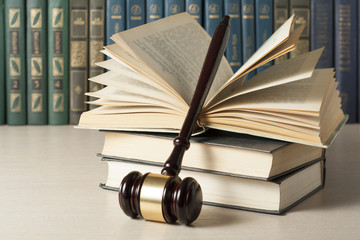 Law concept - Book with wooden judges gavel on table in a courtroom or enforcement office.