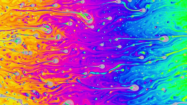 Macro shot of a soap bubble creates a colorful and psychedelic background.