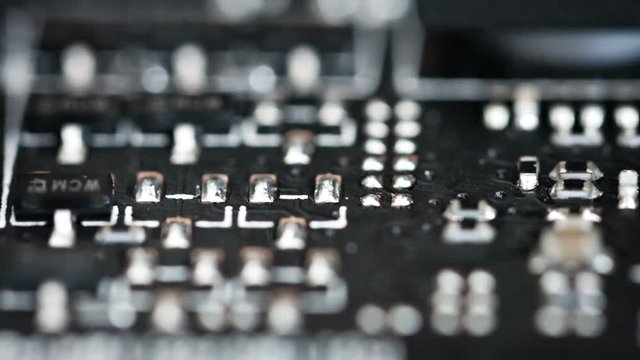 Abstract, shifting selective focus shot of industrial electronic components on a circuit board. Video FullHD
