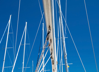 Obraz premium Marina boat masts on blue sky 