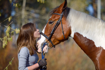 Girl sportswoman and her horse in the spring