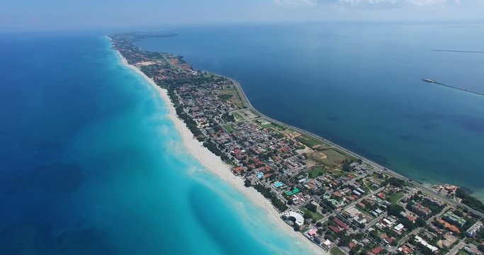 Drone flies above tropical island in the Atlantic Ocean. Bird's-eye view to main streets, houses and coastline of Varadero.