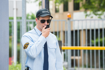 Security Guard Talking On Walkie-talkie