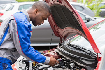 Mechanic Checking Car Battery With Multimeter