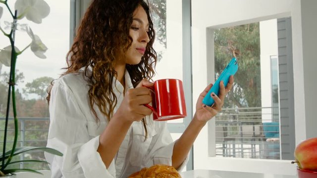 Shot of a woman starting her day with a coffee at home
