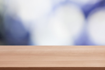 Wood table top on colorful blue bokeh abstract background, can be used for montage or display your products
