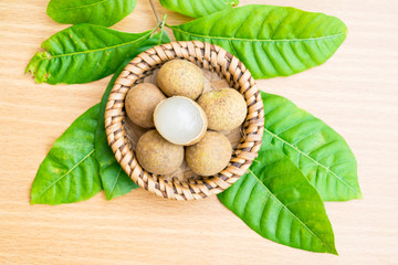 Fresh longan with longan leaf set on wooden table