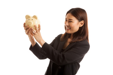 Young Asian business woman with a pig coin bank.