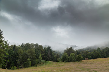 Obraz premium Storm clouds, and adter rain mist in the Romanian mountains, in summer