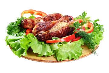 Bright delicious, grilled chicken legs with vegetables on white background.