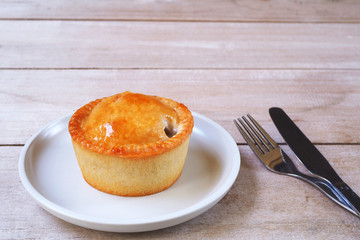 Close up of traditional british pork pie on a wooden table.