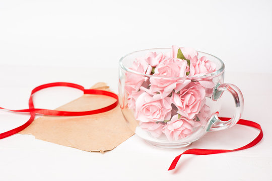 Glass cup full of pink roses with paper sheet