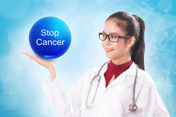 Female doctor holding blue crystal ball with stop cancer sign on medical background.