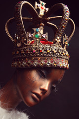 Mannequin in creative golden crown on background