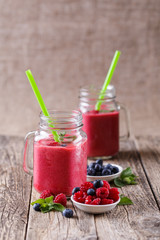 Healthy smoothie with raspberries, berries on plates and drinkin